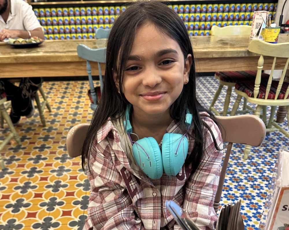 Leem smiling with her turquoise headphones